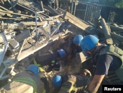 Rescuers release a man from the ruins of a residential building destroyed by a Russian military strike in the town of Toretsk, Donetsk region, Ukraine July 18, 2022, in this photo released by the State Emergency Service of Ukraine.