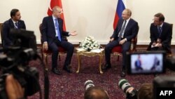 This handout photo taken and released on July 19, 2022, shows Turkish President Recep Tayyip Erdogan (L) talking with Russian President Vladimir Putin during a meeting as part of the Astana Trilateral Summit in Tehran, Iran. (Turkish Presidential Press Se