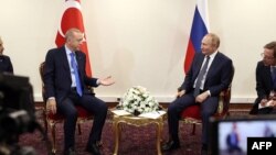 Presiden Turki Recep Tayyip Erdogan (kiri) berbicara dengan Presiden Rusia Vladimir Putin dalam pertemuan sebagai bagian dari KTT "Trilateral Astana" di Teheran, Iran, Selasa (19/7). 