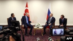 This handout photo taken and released on July 19, 2022, shows Turkish President Recep Tayyip Erdogan (L) talking with Russian President Vladimir Putin during a meeting as part of the Astana Trilateral Summit in Tehran, Iran. (Turkish Presidential Press Se