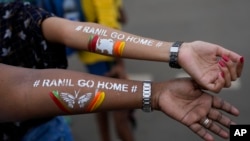 Girls display their arms painted with message "Ranil go home' referring to Prime Minister Ranil Wickremesinghe at the protest site in Colombo, Sri Lanka, July 17, 2022. 