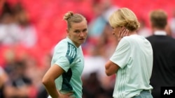 Kapten tim Jerman Alexandra Popp (kiri) berbicara dengan manajer tim Martina Voss-Tecklenburg dalam sesi pemanasan jelang laga final Euro 2022 antara Jerman melawan Inggris di Stadion Wembley, London, pada 31 Juli 2022. (Foto: AP/Alessandra Tarantino)