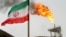 FILE - FILE - A gas flare on an oil production platform is seen alongside an Iranian flag in the Gulf.