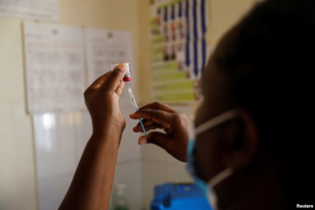 Seorang perawat mempersiapkan vaksin malaria dan jarum suntiknya sebelum memberi vaksinasi kepada bayi di rumah sakit Sub-County Lumumba, Kisumu, Kenya, 1 Juli 2022. (REUTERS/Baz Ratner)