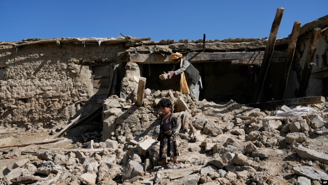 Seorang pria membersihkan puing-puing setelah gempa bumi di desa Gayan, di provinsi Paktika, Afghanistan, Jumat, 24 Juni 2022. (AP/Ebrahim Nooroozi)