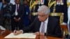 In this photo provided by the Sri Lankan President's Office, newly elected president Ranil Wickremesinghe, signs a document after taking the oath of office, in Colombo, Sri Lanka, July 21, 2022.