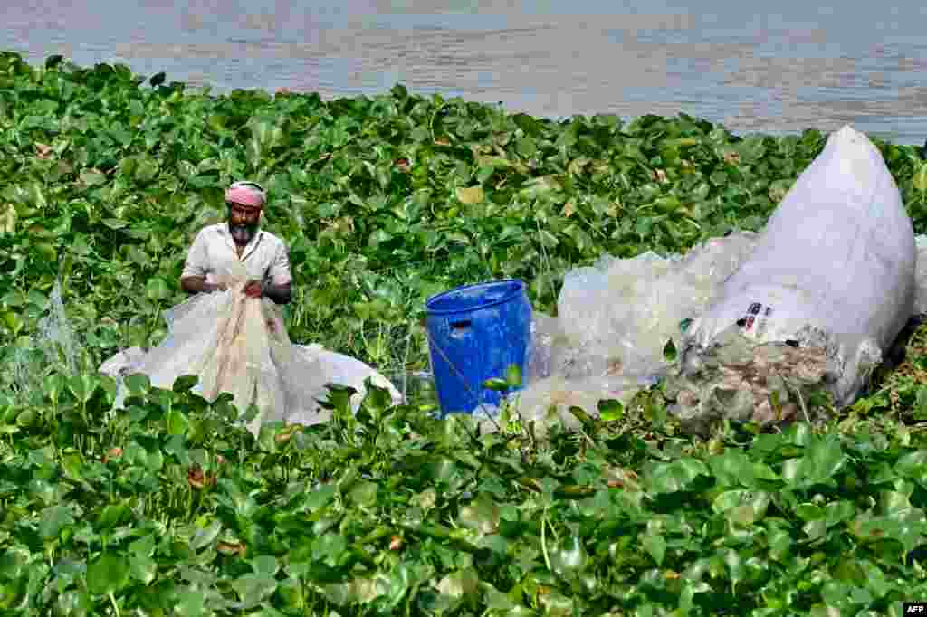 A worker washes used plastic bags in the Buriganga River in Dhaka, Bangladesh.