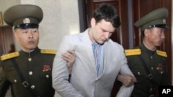 FILE - In this March 16, 2016, file photo, American student Otto Warmbier, center, is escorted at the Supreme Court in Pyongyang, North Korea.