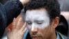 In this Oct. 31, 2018, file photo, a man, who declined to be identified, has his face painted to represent efforts to defeat facial recognition during a protest at Amazon headquarters over the company's facial recognition system, "Rekognition" in Seattle.