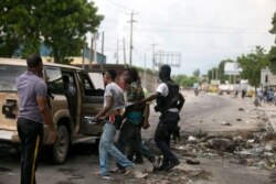 FILE - Protesters are detained by a police officer during a demonstration against fuel shortages in Port-au-Prince, Haiti, Sept. 17, 2019.