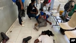 Periodistas yacen en el suelo tras ser baleado por pandillas en el Hospital General de Puerto Príncipe, Haití, el martes 24 de diciembre de 2024.