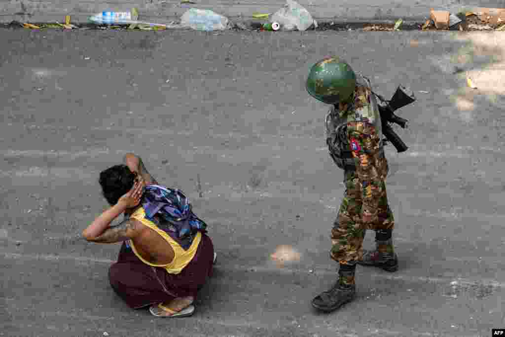 A soldier detains a man during a demonstration against the military coup in Mandalay, Myanmar.