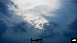 FILE - In this April 21, 2020 file photo, a pumpjack is pictured as a storm moves in Oklahoma City. 