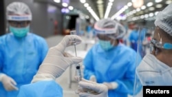 FILE - A medical worker prepares a syringe with a dose of China's Sinovac coronavirus vaccine at the Central Vaccination Center, inside the Bang Sue Grand Station, in Bangkok, Thailand, May 24, 2021.