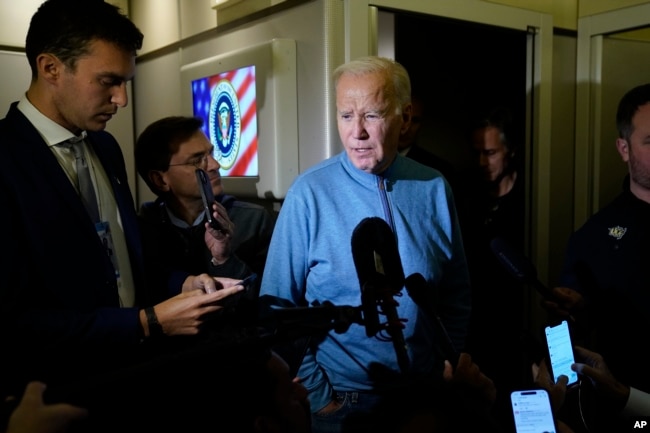 FILE - President Joe Biden talks to reporters aboard Air Force One during a refueling stop at Ramstein Air Base in Germany, Oct. 18, 2023, as he travels back from Israel to Washington.