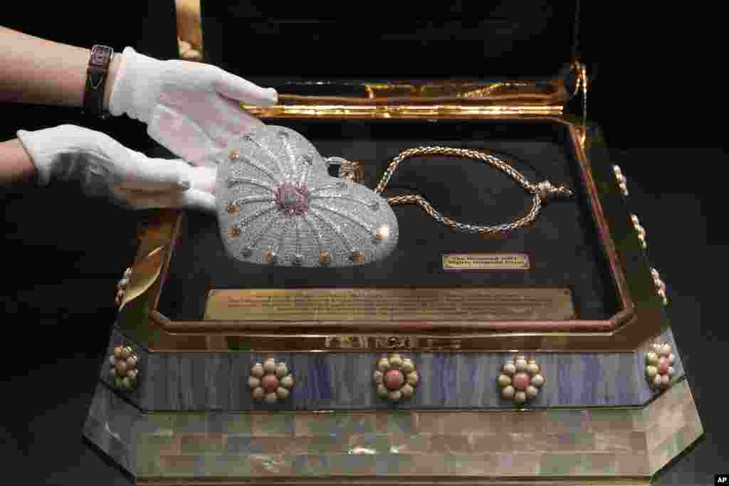 A staff member from the Christie&#39;s Hong Kong, displays a heart-shaped handbag, the Mouawad &quot;1001 Nights Diamond Purse&quot; which incorporated 4,517 diamonds with a total weight of 381.92 carats during an auction preview in Hong Kong.