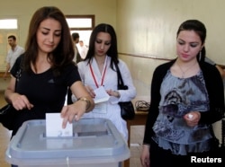 FILE - Women vote at a polling station for a parliamentary election, in Damascus, May 7, 2012.