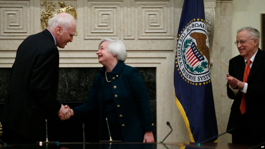 Janet Yellen estrecha la mano a Daniel K. Tarullo, luego de la juramentación. Obaseva el esposo de Yelenn, George Akerloff.