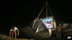 FILE—A boat that was carrying decomposing corpses is lifted to shore by authorities at the Vila do Castelo port in Braganca, Brazil, early Monday, April 15, 2024. 