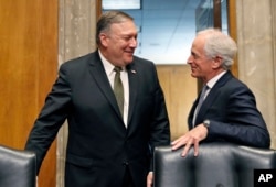 El secretario de estado designado, Mike Pompeo, actual director de la CIA, conversa con el presidente de la Comisión de Relaciones Exteriores del Senado, Bob Corker, durante un descanso en la audiencia de confirmación del primero. Abril 12 de 2018.