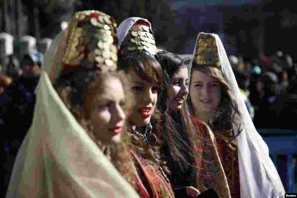 Girls wearing traditional Palestinian costumes take part in a Christmas procession at Manger Square in front of the Church of the Nativity in the West Bank town of Bethlehem, Dec. 24, 2013. 