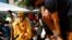 Brian Gardener, left, wears his middle school graduation cap and gown as he kneels with demonstrators in remembrance of George Floyd, June 13, 2020, near the White House in Washington. 