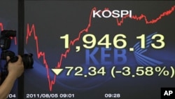 A photographer takes pictures of a screen showing the Korea Composite Stock Price Index at the Korea Exchange Bank headquarters in Seoul, South Korea, August 5, 2011