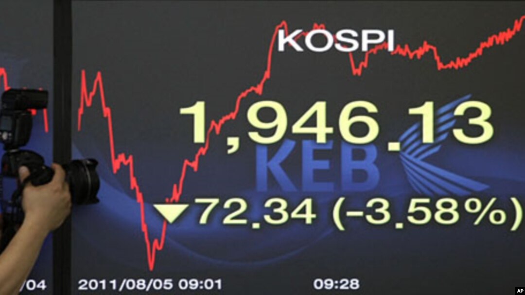 A photographer takes pictures of a screen showing the Korea Composite Stock Price Index at the Korea Exchange Bank headquarters in Seoul, South Korea, August 5, 2011