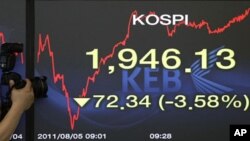 A photographer takes pictures of a screen showing the Korea Composite Stock Price Index at the Korea Exchange Bank headquarters in Seoul, South Korea, August 5, 2011