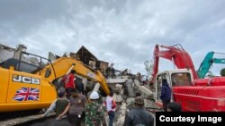 Dua alat berat excavator membantu upaya evakuasi korban yang terjebak di bawah reruntuhan kantor Gubernur Sulbar yang roboh, Jumat (15/1/2021) (Foto : Taufiq Lau/ Pemprov Sulsel).