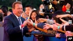 Actor and former Governor of California Arnold Schwarzenegger shakes hands with Chinese fans as he arrives for the grand opening of the 5th annual Beijing International Film Festival in Beijing, April 16, 2015. 