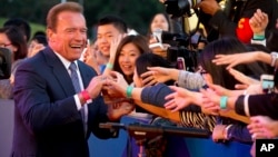 FILE - Actor and former Governor of California Arnold Schwarzenegger shakes hands with Chinese fans as he arrives for the grand opening of the 5th annual Beijing International Film Festival in Beijing, April 16, 2015. 