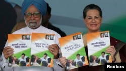 India's Prime Minister Manmohan Singh (L) and Chief of India's ruling Congress party Sonia Gandhi hold their party's manifesto for the April/May general election in New Delhi, March 26, 2014.