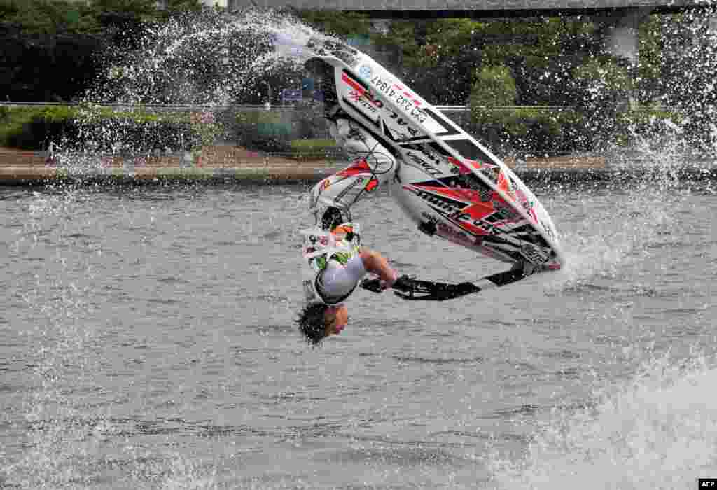 A man flips his personal watercraft during a demonstration on the Sumida river in Tokyo, Japan.