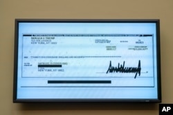 A copy of a check from Donald Trump to Michael Cohen, his former personal lawyer, is displayed as he testifies before the House Oversight and Reform Committee on Capitol Hill in Washington, Feb. 27, 2019.