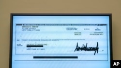 A copy of a check from Donald Trump to Michael Cohen, his former personal lawyer, is displayed as he testifies before the House Oversight and Reform Committee on Capitol Hill in Washington, Feb. 27, 2019.
