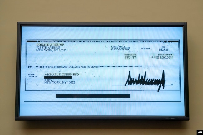 FILE - A copy of a check from Donald Trump to Michael Cohen, his former personal lawyer, is displayed as he testifies before the House Oversight and Reform Committee on Capitol Hill in Washington, Feb. 27, 2019. (AP Photo/J. Scott Applewhite)