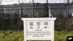 South Korean army soldiers patrol behind a barbed-wire fence near a directional sign showing the distance to North Korea's city Kaesong and South Korea's capital Seoul at the Imjingak Pavilion near the border village of Panmunjom, South Korea, July 5, 201