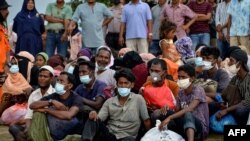 Warga Rohingya dari Myanmar, duduk di garis pantai desa Lancok, di Kabupaten Aceh Utara, Indonesia, 25 Juni 2020. 