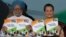 India's Prime Minister Manmohan Singh (L) and Chief of India's ruling Congress party Sonia Gandhi hold their party's manifesto for the April/May general election in New Delhi, March 26, 2014.
