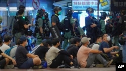 Polisi menahan para demonstran dalam pawai menandai ulang tahun penyerahan Hong Kong dari Inggris ke China, Rabu, Juli. 1, 2020, di Hong Kong.