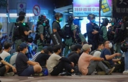 Police detain protesters during a march marking the anniversary of the Hong Kong handover from Britain to China, Wednesday, July. 1, 2020, in Hong Kong.