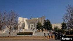 A security official stands guard outside the Supreme Court in Pakistan where PM Gilani was scheduled...