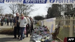 Ljudi plaču prolazeći pored škole Stekske u Lomelu, u Belgiji, koju su pohadjali neki od poginulih djaka.