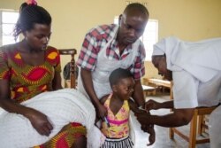 FILE - A girl reacts as she receives an injection during a nationwide vaccination campaign against measles, rubella and polio targeting all children under 15 years old in Nkozi, about 84 km from Kampala, Uganda, Oct. 19, 2019.