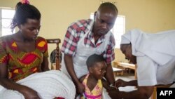 FILE - A girl receives an injection during a nationwide vaccination campaign against measles, rubella and polio targeting all children under 15 years old in Nkozi, about 84 km from Kampala, Uganda, Oct. 19, 2019. 