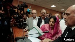 Mamnoon Hussain (3rd R), presidential candidate of the Pakistan Muslim League-Nawaz (PML-N) party, smiles as he submits his nomination papers for the upcoming presidential election at the High Court in Islamabad, July 24, 2013.