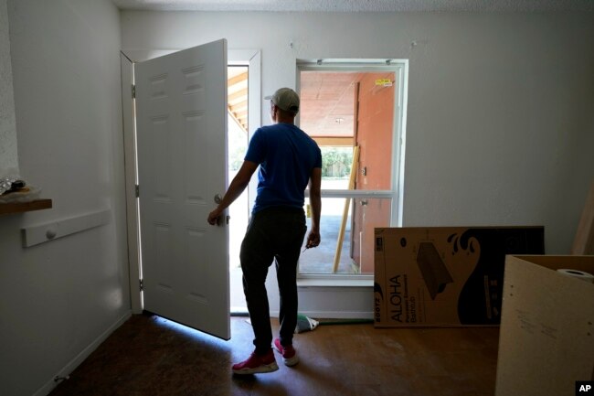 A rafter from Cuba who recently arrived in Miami illegally by sea, seeking to escape political and economic difficulties, is seen at a worksite, Wednesday, July 6, 2022, in Austin, Texas. (AP Photo/Eric Gay)