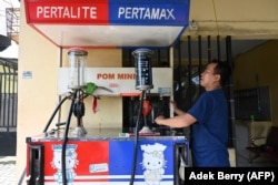 Seorang petugas pompa bensin di sebuah SPBU pinggir jalan di Jakarta pada 29 Mei 2022. (Foto: AFP/ADEK BERRY)