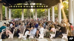 FILE: People gather at an evening vigil for author Salman Rushdie who was attacked, Aug. 12, 2022, in Chautauqua, N.Y. Rushdie was stabbed as he was about to give a lecture at the Chautauqua Institution.